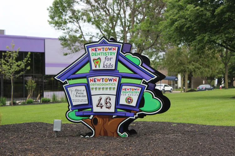 Exterior sign photo that includes sign for the Newton office of the Oral & Maxillofacial Surgery Center in Newton PA