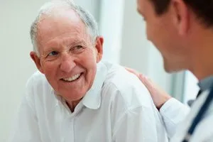 Photo of older patient asking his oral surgeon questions