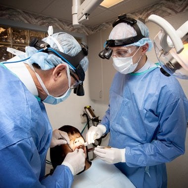 Dentists extracting a patient's tooth